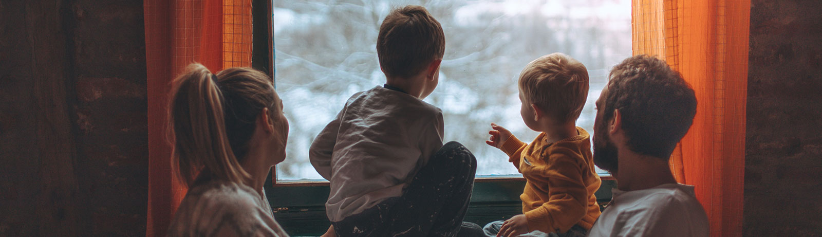 Young family watching sunrise in living room
